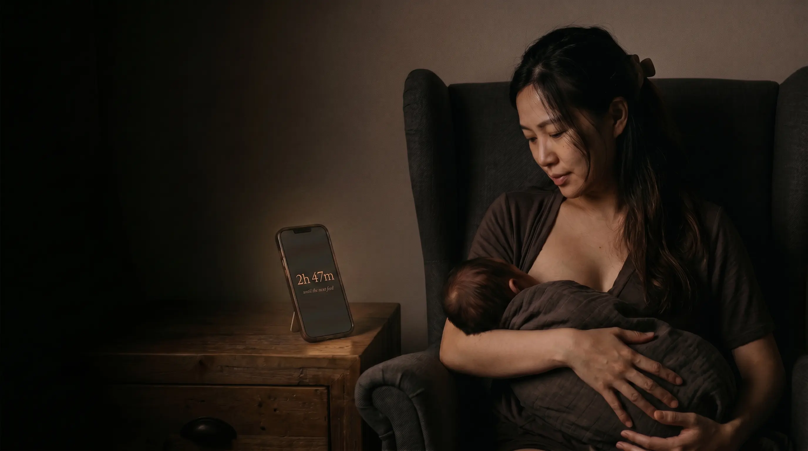 A mother nursing her newborn in the dark at 3am, the countdown glowing softly on the nightstand phone: 2h 47m until the next feed